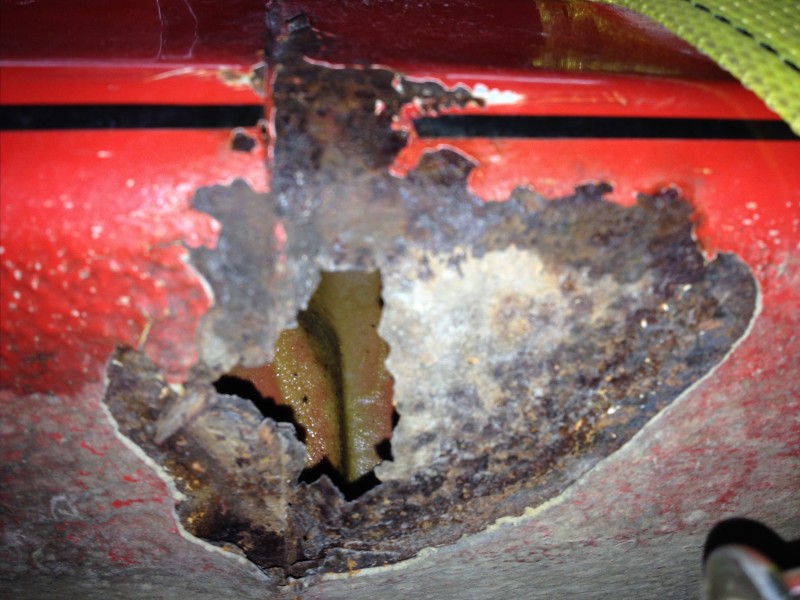 29594505911_6e5e580b99_c Close-up of a red metal surface with a large rusted hole and corrosion around the edges