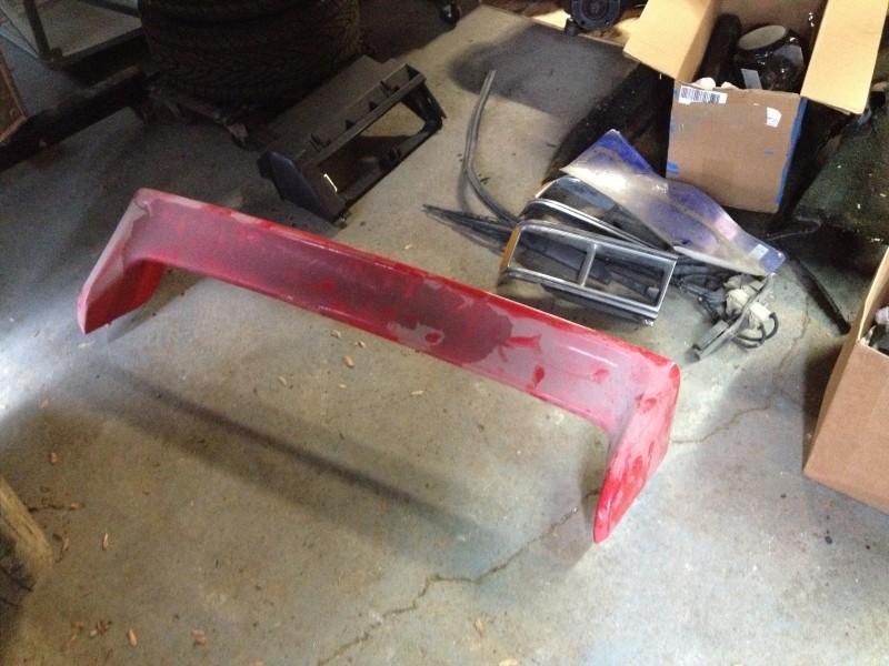 29675817705_d5e36353ae_c Red car spoiler placed on a concrete floor with other car parts and cardboard boxes nearby