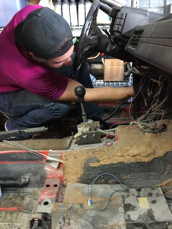 29698679385_10323af561_c Person working on wiring inside a vehicle's interior without seats, focusing on dashboard and floor area