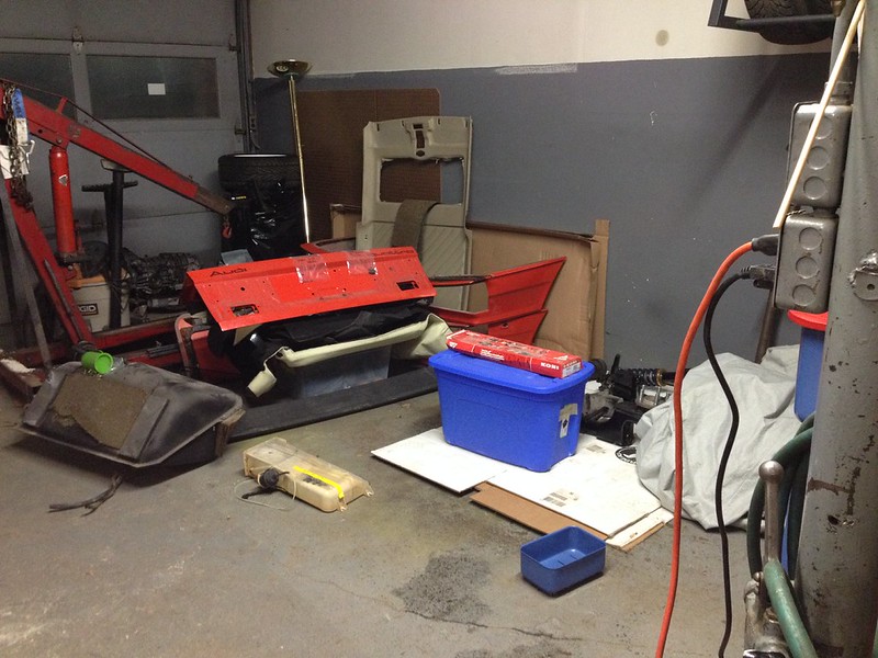 29920735051_9aeba9aa87_c Disorganized garage corner with car parts, a blue plastic bin, and various tools scattered on the floor