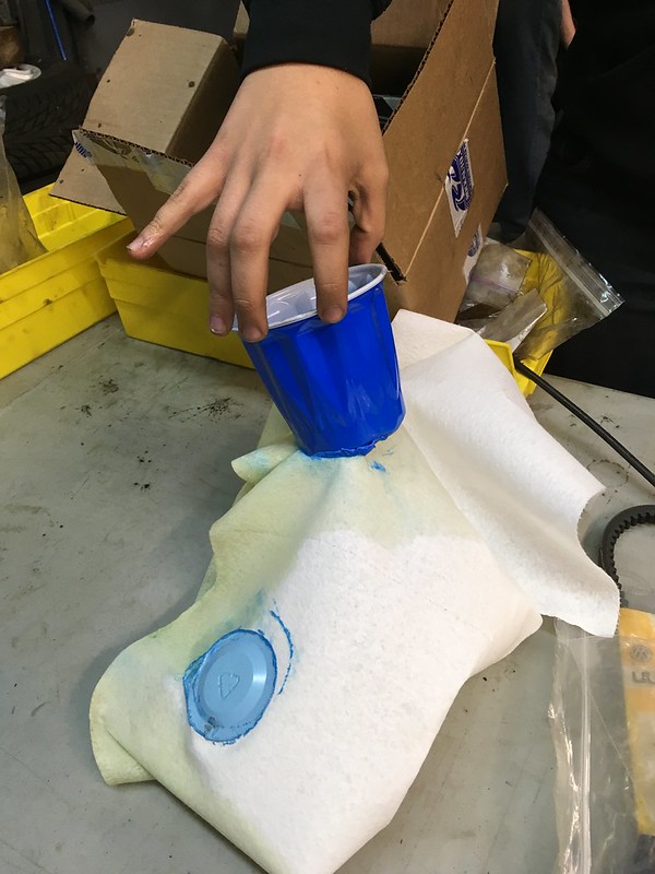 30330993560_3935c04d4b_c Hand pressing a blue plastic cup onto white fabric with a blue circular imprint visible on the fabric