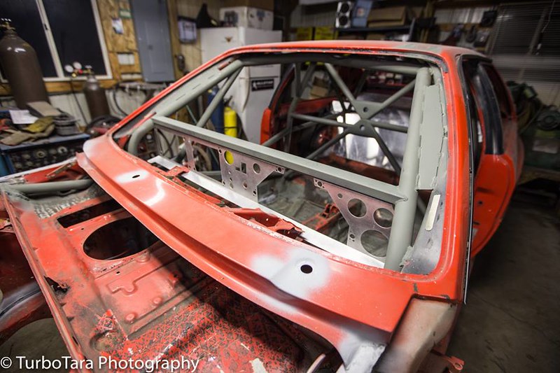 Interior view of a UR Quattro stripped down to its metal frame with a visible roll cage inside