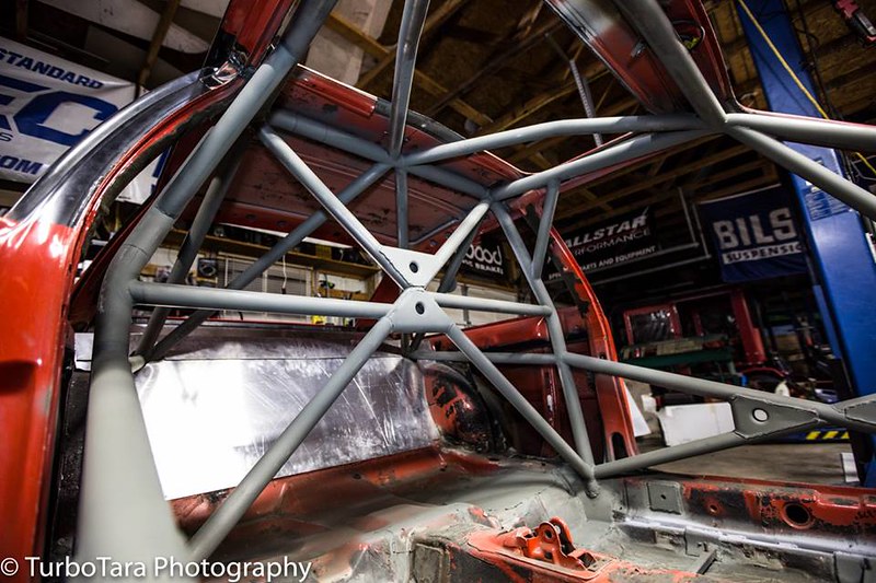 Interior of a UR Quattro frame showing a gray roll cage structure in a workshop environment