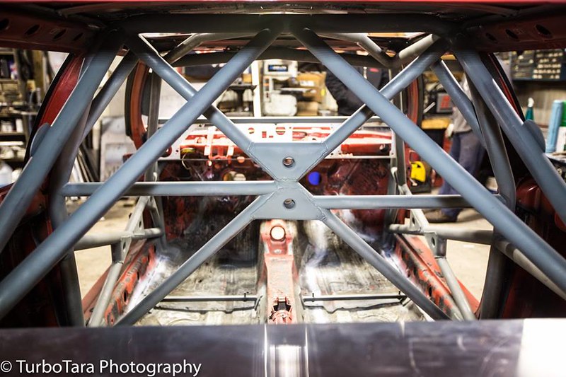 Interior view of a bare UR Quattro frame with a grey metal roll cage and no seats
