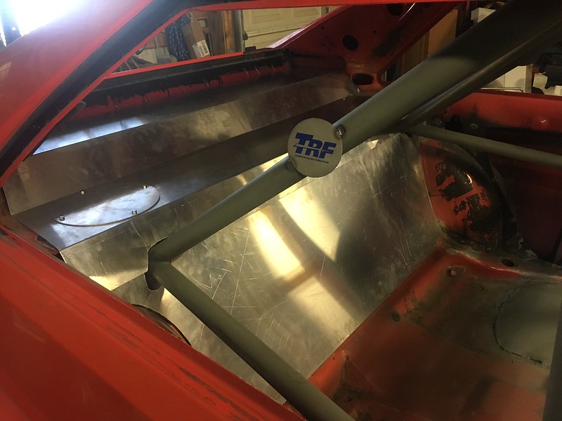 Interior of a UR Quattro stripped to metal with a roll cage and TRF sticker on a bar