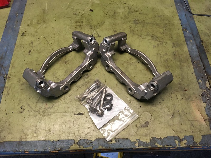 33384461735_8a788cc1bb_c Two metal brake caliper brackets with screws and washers on a worn workbench for Group B UR Quattro