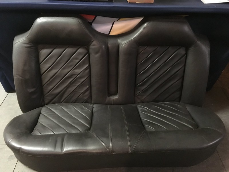 Close-up of a black leather UR Quattro seat with diamond pattern stitching, designed for two passengers.