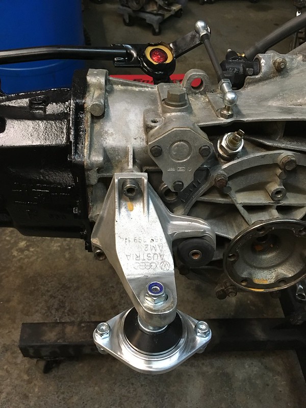 Close-up view of an UR Quattro transmission showing a gearbox assembly with several mechanical parts, including a mount and linkage.