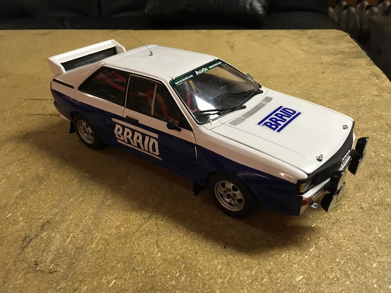 White and blue rally UR Quattro model with BRAD decals on the hood and side, placed on a wooden surface