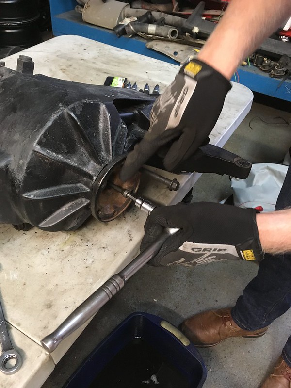 34052923343_5940e09855_c A person wearing gloves using a torque wrench to tighten a bolt on a mechanical part on a workbench