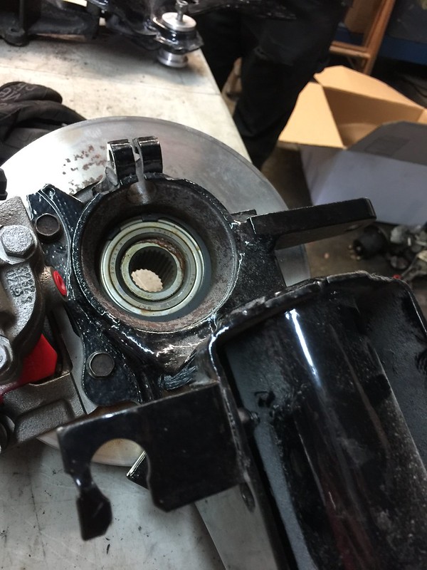 Close-up of disassembled UR Quattro suspension components showing a bearing assembly and black metal parts.