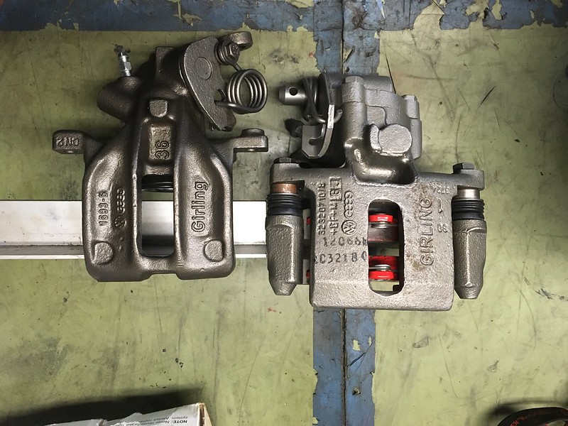 34475795705_f8ba98fbb7_c Two metallic UR Quattro brake calipers placed side by side on a workshop floor