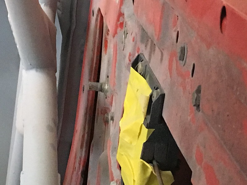 Close-up of a red UR Quattro panel showing a metal bolt and yellow masking tape applied around a black section.