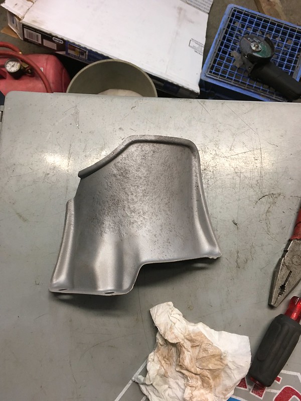 A metallic, unfinished UR Quattro part resting on a workbench, surrounded by tools and a piece of crumpled paper towel.