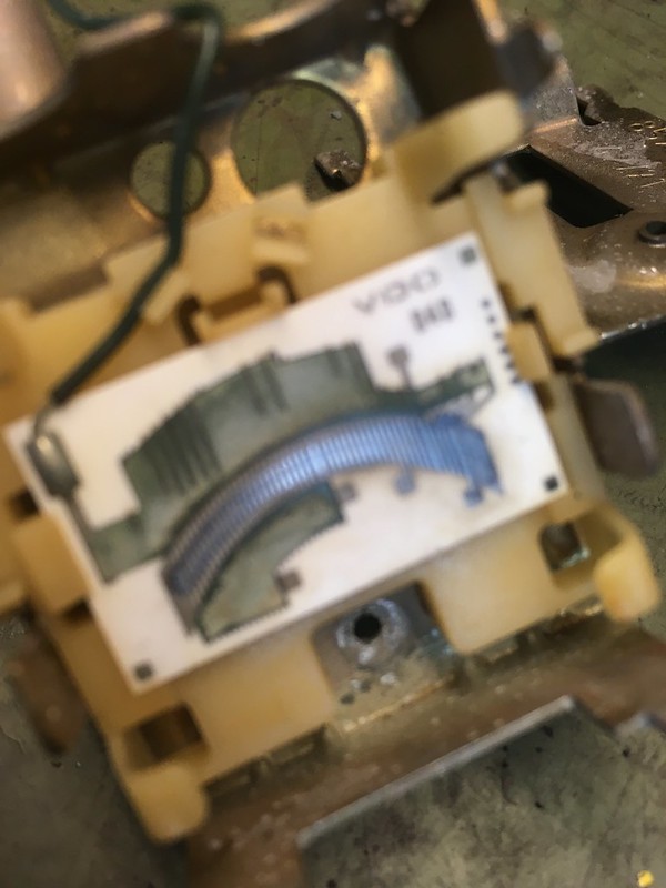 Close-up of an electronic UR Quattro component showing a circuit board with a curved metal trace and visible connections.