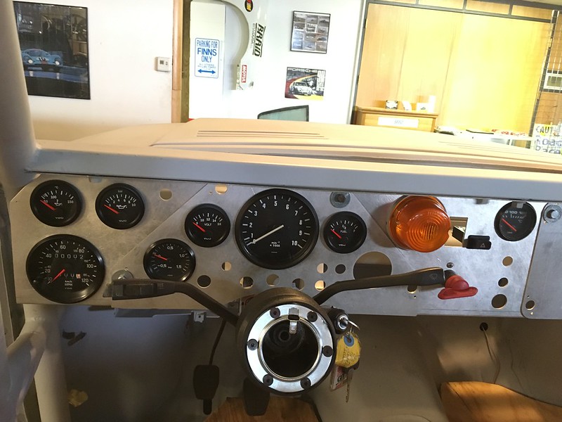 View of a UR Quattro rally dashboard featuring various gauges, including speedometer, fuel gauge, and warning lights, with an unfinished and industrial design.