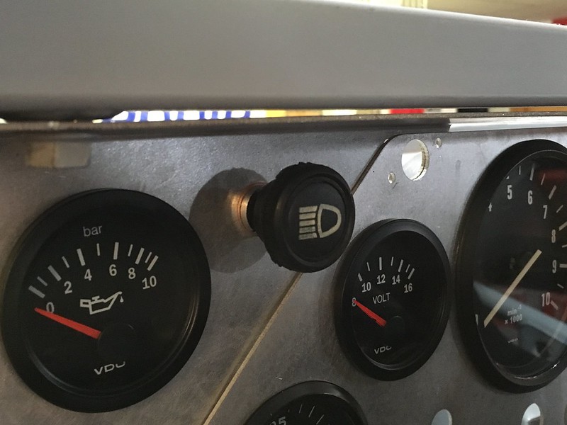 Close-up of a UR Quattro rally dashboard showing various gauges including oil pressure, voltage, and a headlight switch.